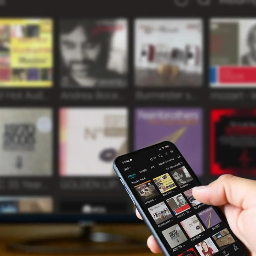 pro13 Hand holding smartphone to control eWEAT HiFi Music Streamer via app, with music album covers displayed on a screen in the background - eweat.com