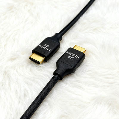 Black HDMI 8K Cable with Gold-Plated Connectors on White Wool Surface